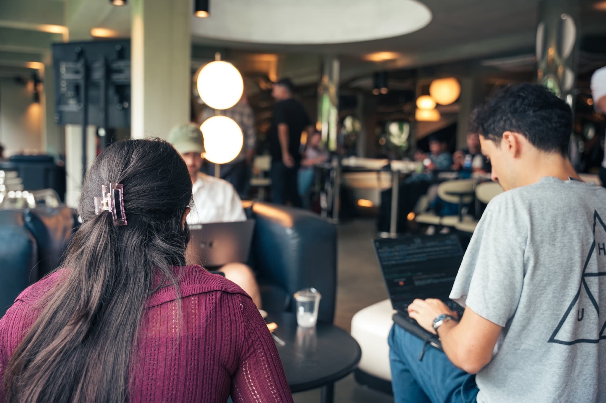 People working on laptops in the UN:HOUR lounge during Café Cursor Bangkok