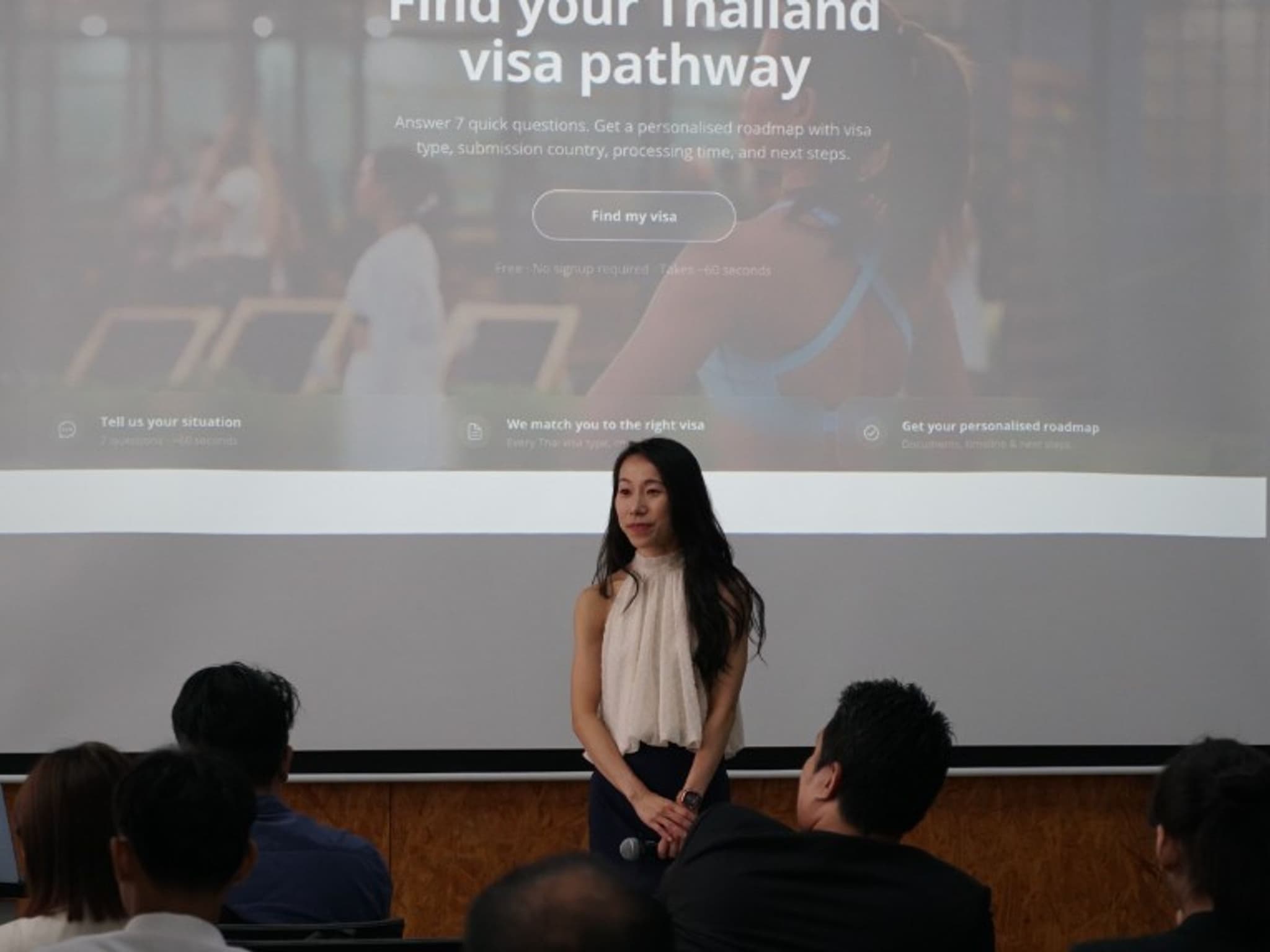 Priscilla Yeung on stage at KX Knowledge Xchange with the Issa Compass visa pathway screen behind her during the AIKS StartUp Case Challenge 2026 Opening Day keynote