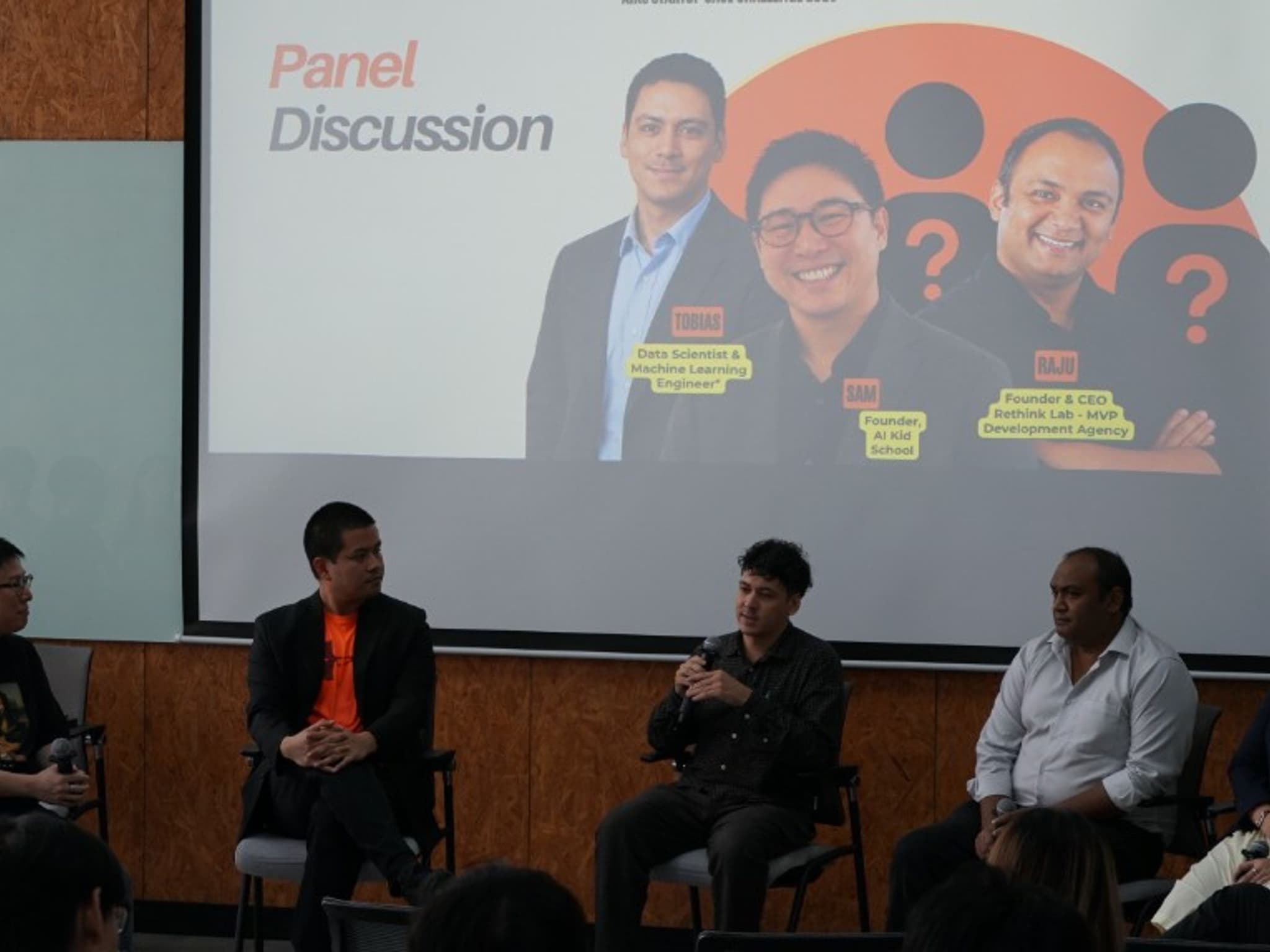 Founders and mentors on stage for a panel discussion at the AIKS StartUp Case Challenge 2026 Opening Day, with Sam Dhanakorn of AI-Kid School among the speakers