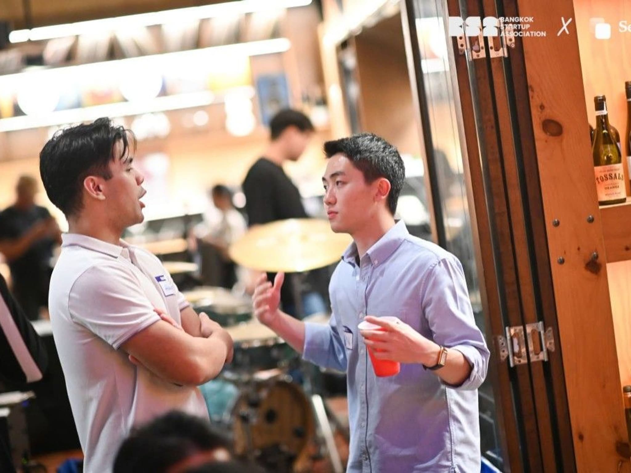 Pan Karnjanaekarin of Issa Compass talking with another founder at the Bangkok Startup Association NØTWORKING Night at Vinyl & Wine, Emsphere
